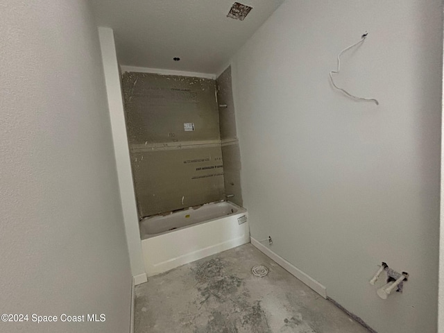 bathroom with concrete floors and a washtub