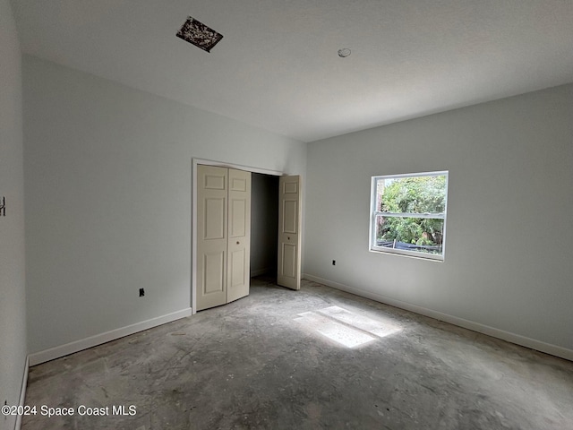 unfurnished bedroom with concrete flooring