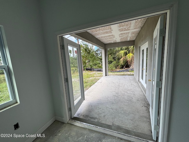 doorway to outside with a wealth of natural light and concrete flooring