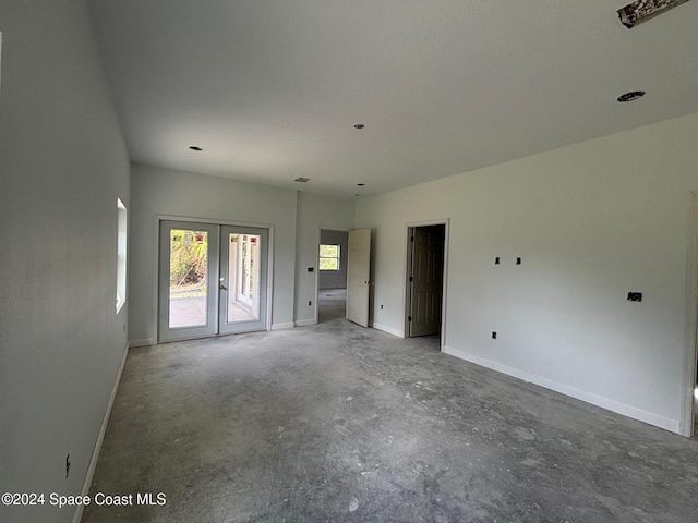 unfurnished room featuring concrete floors and french doors