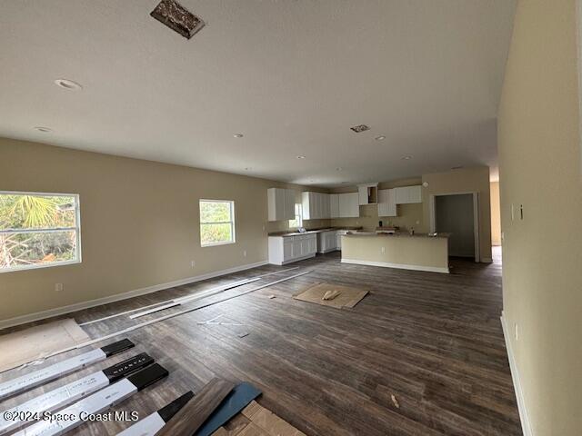 unfurnished living room with dark wood-type flooring