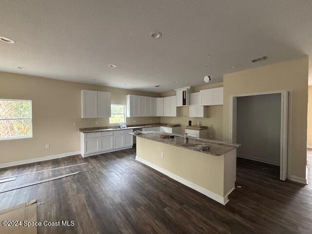 kitchen featuring white cabinetry, a center island, and dark hardwood / wood-style floors