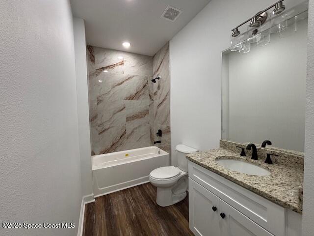 3250 San Jose Ave SE, Palm Bay, FL 32909 - full bath featuring wood finished floors, toilet, vanity, and tub / shower combination