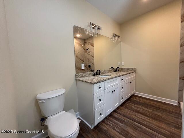 3250 San Jose Ave SE, Palm Bay, FL 32909 - full bathroom featuring baseboards, toilet, double vanity, and wood finished floors