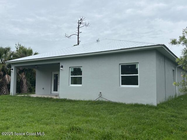 3250 San Jose Ave SE, Palm Bay, FL 32909 - back of house with a lawn and stucco siding