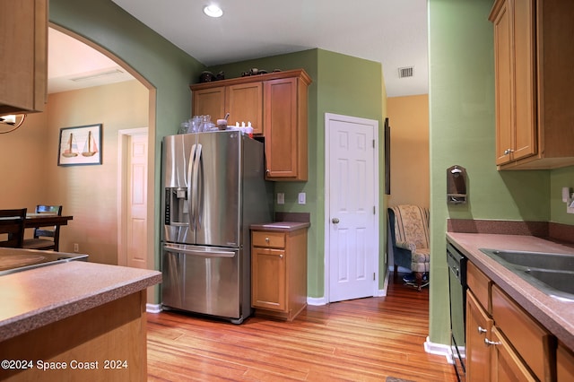 kitchen featuring light hardwood / wood-style flooring, stainless steel refrigerator with ice dispenser, dishwasher, and sink