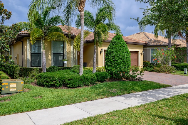 view of front of house with a garage and a front lawn