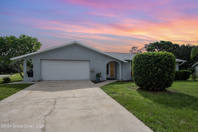 single story home featuring a yard and a garage