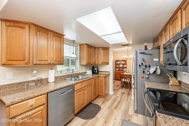 kitchen with sink, a notable chandelier, hanging light fixtures, light hardwood / wood-style flooring, and appliances with stainless steel finishes