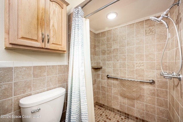 bathroom with a shower with curtain, tile walls, and toilet