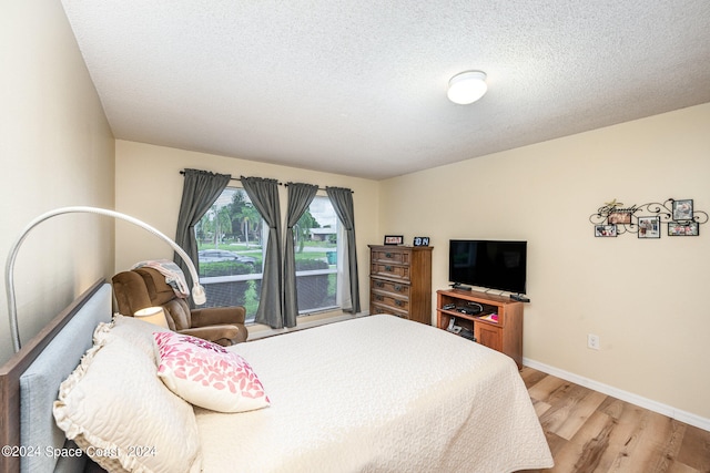 bedroom featuring a textured ceiling and light hardwood / wood-style floors