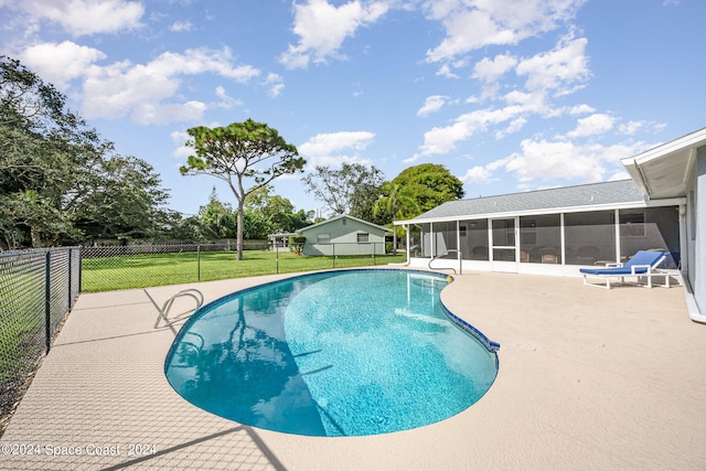 view of pool featuring a sunroom, a patio area, and a yard