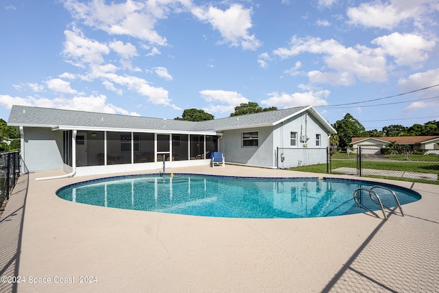 view of pool with a sunroom and a patio