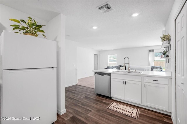 kitchen featuring white cabinets, white refrigerator, dark hardwood / wood-style flooring, stainless steel dishwasher, and sink