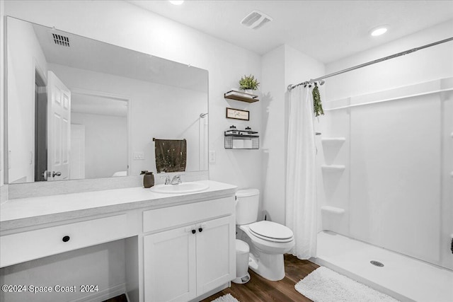 bathroom with walk in shower, vanity, toilet, and wood-type flooring