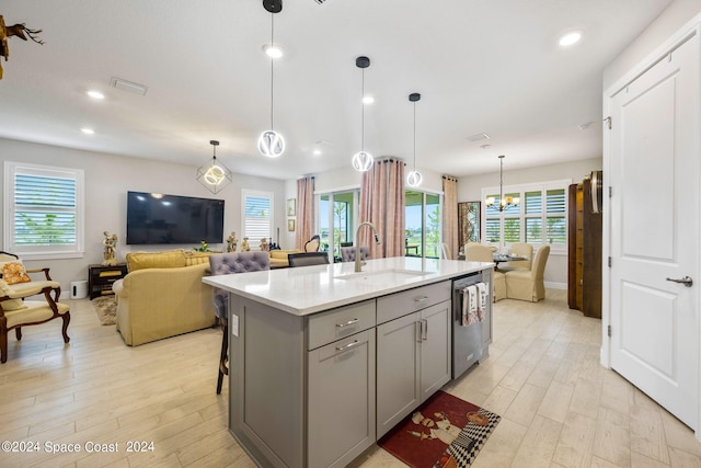 kitchen featuring a sink, gray cabinetry, light wood-style flooring, and open floor plan