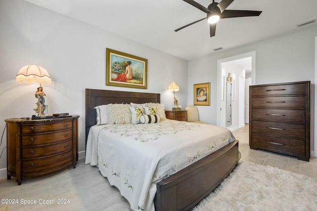 bedroom featuring a ceiling fan, visible vents, and light wood-style flooring