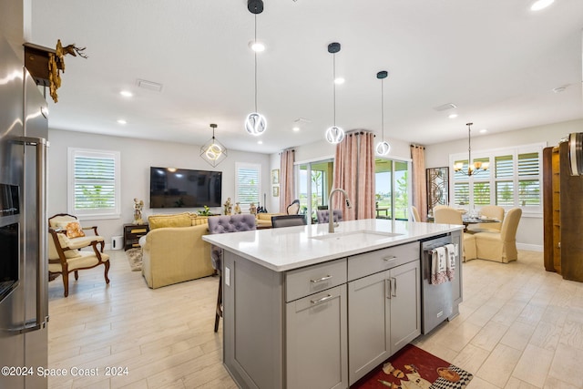 kitchen with a sink, gray cabinets, stainless steel appliances, and open floor plan