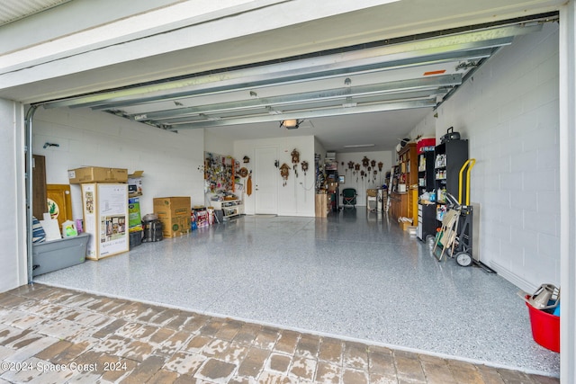 garage with concrete block wall and a garage door opener
