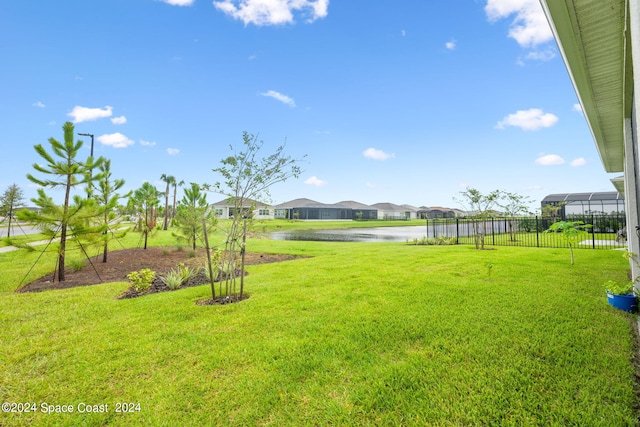 view of yard featuring fence, a water view, and a residential view