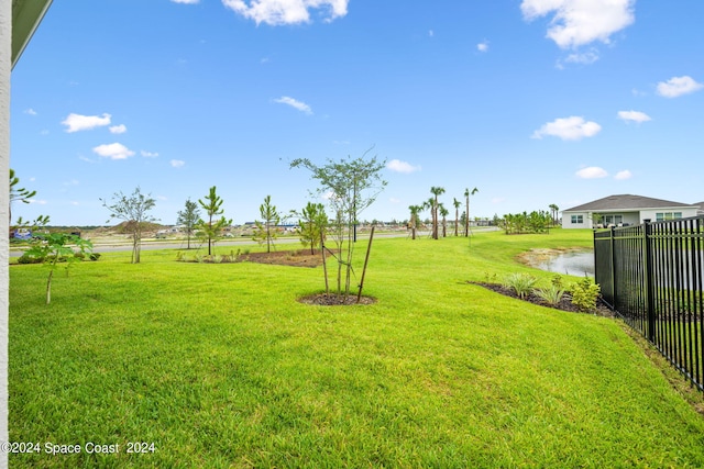 view of yard featuring a water view and fence
