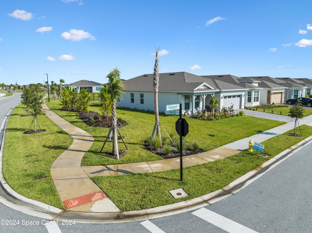 view of front facade with driveway, a residential view, a front lawn, and a garage