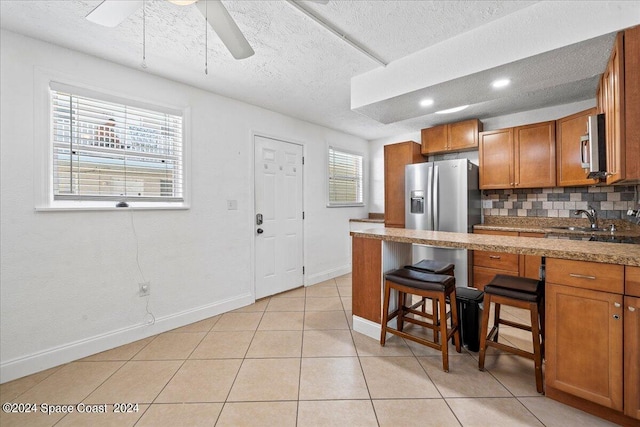 kitchen with decorative backsplash, a wealth of natural light, ceiling fan, and sink