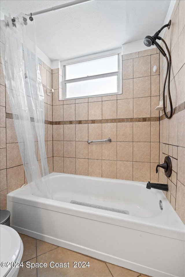 bathroom with a textured ceiling, shower / tub combo, toilet, and tile patterned floors