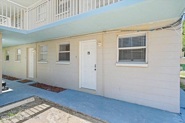 view of exterior entry with a balcony