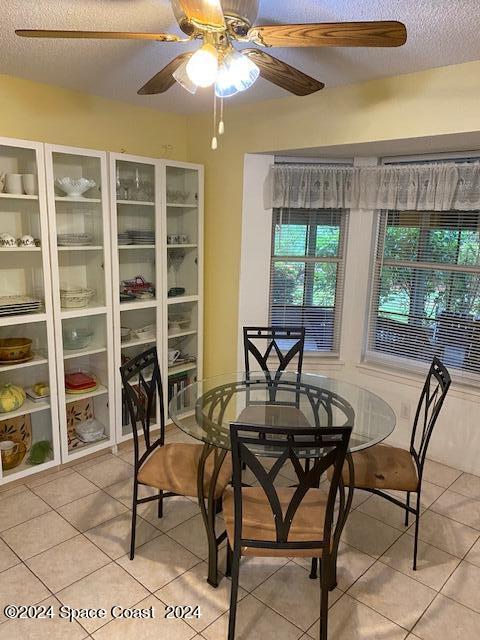 tiled dining area featuring ceiling fan and a textured ceiling