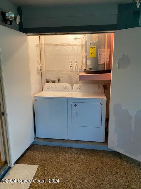 washroom featuring water heater and washer and clothes dryer