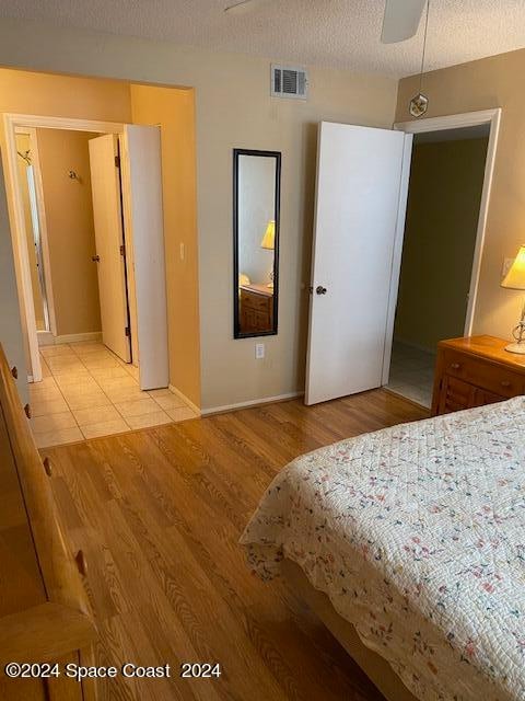 unfurnished bedroom featuring ceiling fan, a textured ceiling, and light hardwood / wood-style floors