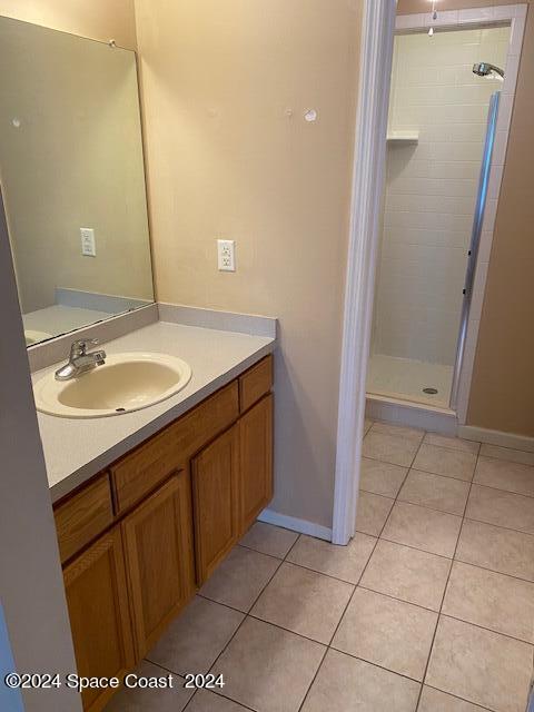 bathroom with vanity, tile patterned flooring, and tiled shower