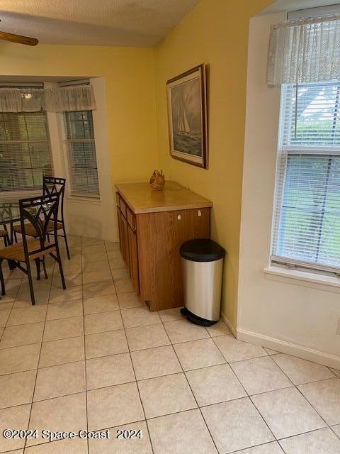 kitchen featuring light tile patterned flooring, ceiling fan, and a textured ceiling