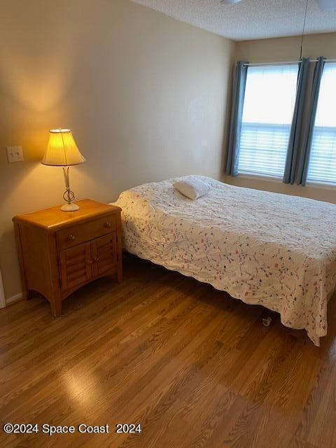 bedroom with hardwood / wood-style flooring and a textured ceiling