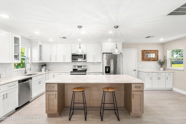 kitchen with sink, white cabinets, a center island, and stainless steel appliances