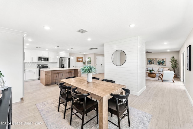 dining space featuring ceiling fan and light hardwood / wood-style floors