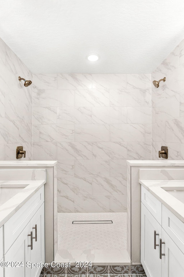 bathroom with vanity and tiled shower