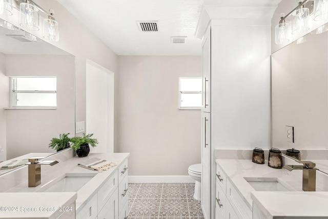 bathroom featuring toilet, tile patterned flooring, and vanity