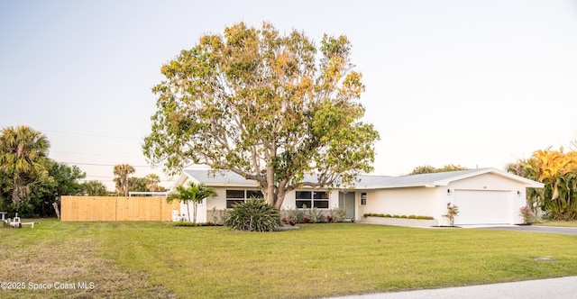 single story home featuring a garage and a front yard