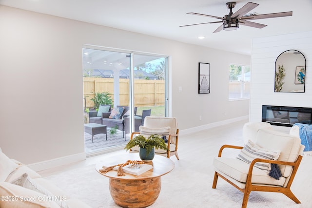 sitting room featuring ceiling fan and a fireplace