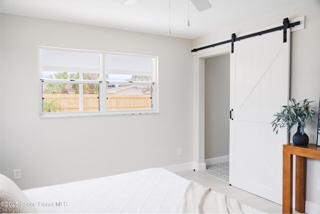 bedroom with ceiling fan and a barn door