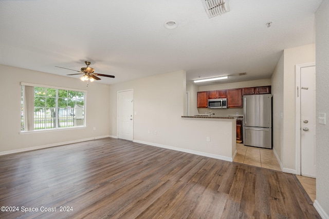 unfurnished living room featuring light hardwood / wood-style flooring and ceiling fan