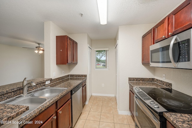 kitchen with a textured ceiling, light tile patterned flooring, sink, stainless steel appliances, and ceiling fan