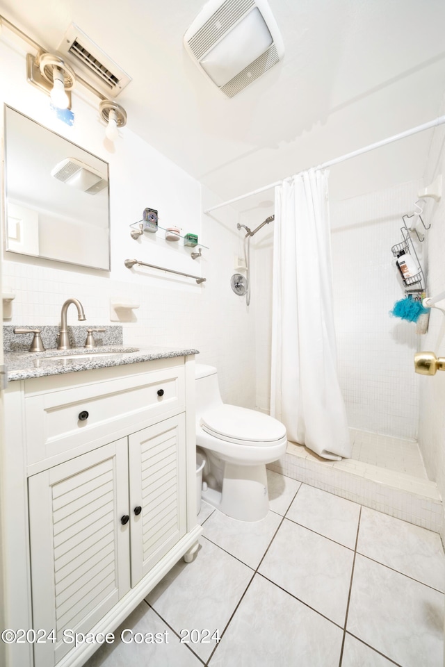 bathroom with tile patterned flooring, tasteful backsplash, vanity, toilet, and walk in shower