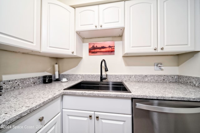 kitchen featuring stainless steel dishwasher, white cabinetry, and sink