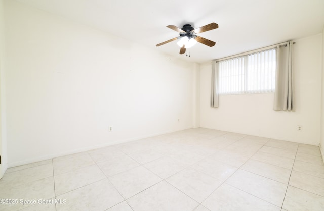 spare room with ceiling fan and light tile patterned flooring