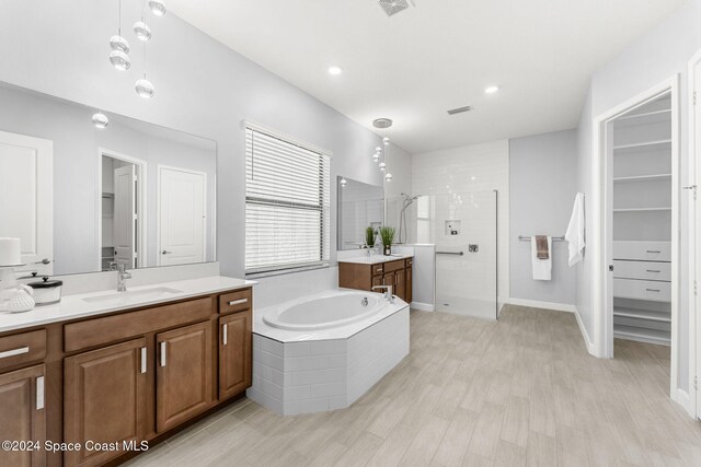 bathroom featuring hardwood / wood-style flooring, vanity, and independent shower and bath