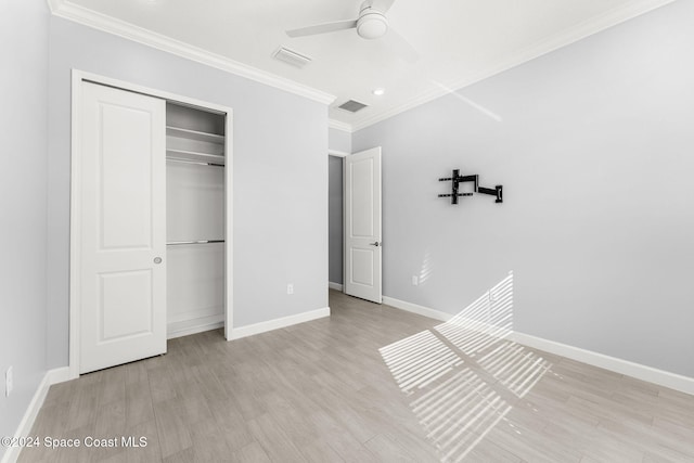 unfurnished bedroom with ceiling fan, crown molding, light hardwood / wood-style flooring, and a closet