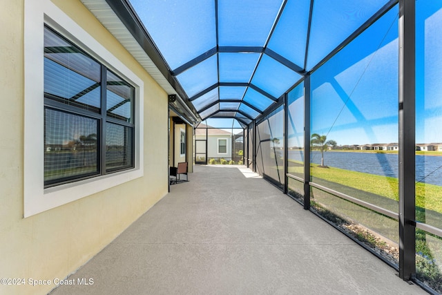 unfurnished sunroom with a water view and lofted ceiling